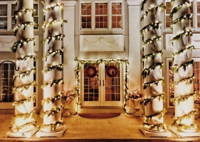 Live garland and lights on pillars in front of a Schenectady area home