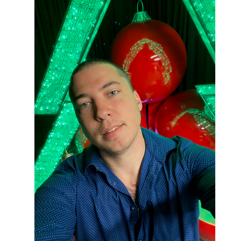 Captain Christmas selfie in front of giant christmas ornaments